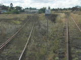 An industrial siding away to the left of the main line. The siding has a fence blocking traffic.