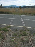 A look north of Williamsdale across the railway crossing. The shine on the track appears to be from road traffic.