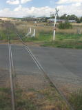 The rail car continues over the crossing. In the far distance the Snowy Junction platform can be made out.