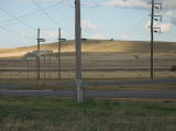 Polo Flat road, and beyond the signs the race track is visible.