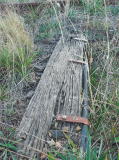 A sleeper with cable attached, possibly for signalling or for a railway crossing. We also see how far the rail has been bent from the sleeper.