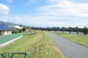 A suburban train leaves the railway bridge over the Hutt River, heading towards Woburn station. The perspective is directly south from the top of Whites Line West.