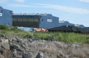 A southward facing shot of the blue 'Alstom' buildings. One of the houses in the suburban redevelopment can be seen on the right.