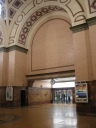 The inside foyer of Wellington Railway Station. This is the main entrance to the station itself. The clock in front of the doors reads around seven minutes to midnight.