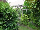 A wooden archway leads to the eastern side of the house.
