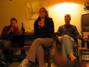 Paul, Shami, and Iain continue the conversation in room 6 of the Sand Castle Motel. On the bottom left and right are the feet of Jann and Denise.