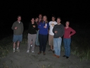 The gang celebrate New Years at midnight on Peka Peka beach. A firework rises in the distance above Mauricio's head.