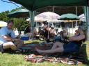 Willie, Snaiet, and Denise under the gazebo at Tauherenikau. Willie continues to apply sun screen.