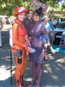 Two young women are painted in local colours as part of a Dulux promotion. The gun and backpack are used to apply sunscreen to anyone who wants some.