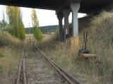 Looking through the Monaro Highway overbridge. The line here has been abandoned for some time. The points are set for the saleyard.