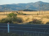 Looking northeast across the Cooma highway to the railway embankment, north of the former railway crossing.