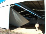 A door of the carriage shed hangs on precariously as Erik investigates further. A neighbour reported that the door had blown in during the previous night.