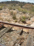 Looking through the gap between the rail and the track bed, water still flows three days after the flood.
