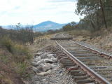 Rocks from a nearby cutting have been gathered and placed on top of the concrete base, to help bring the track bed back up to the rail. A temporary stop block has been placed across the line at 341.7km.