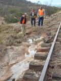 Flood water carved away a path towards the valley, exposing sleepers near 341.7km.